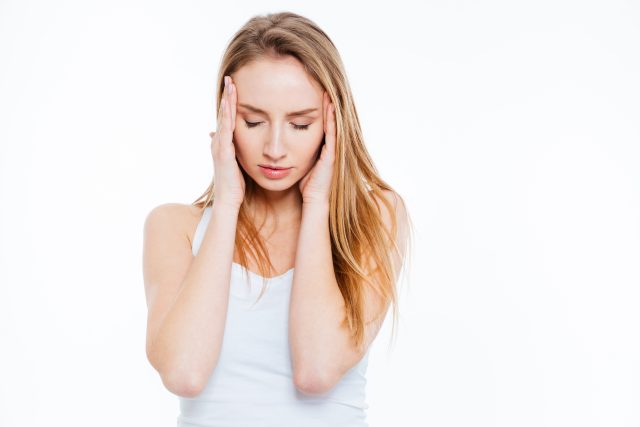 Young woman having headache isolated on a white background